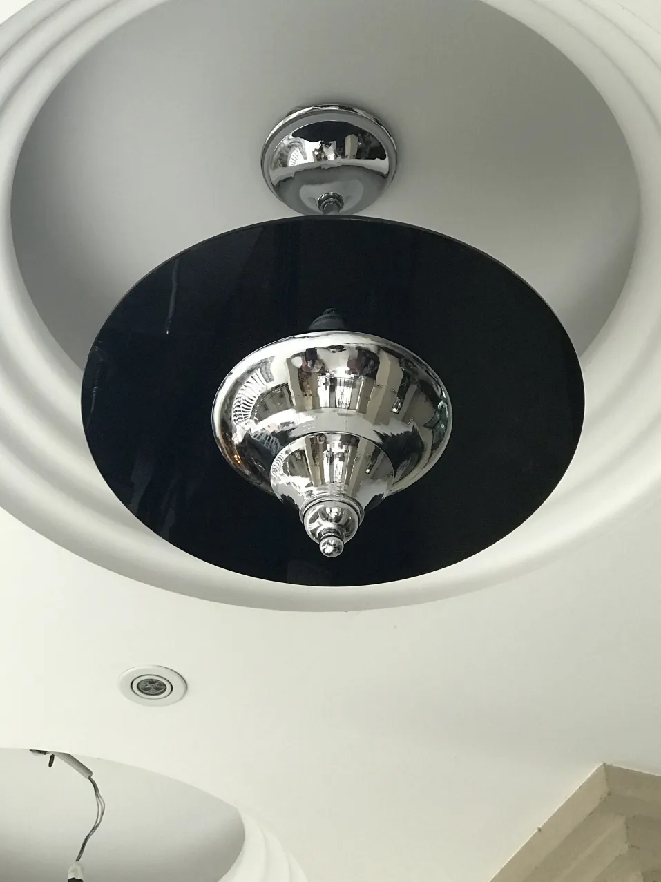 古董黑色吊灯，光亮，装在白色天花板上。