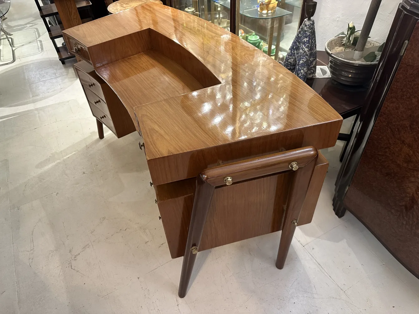 Bureau ancien avec forme unique, doté de tiroirs et pattes élégantes.