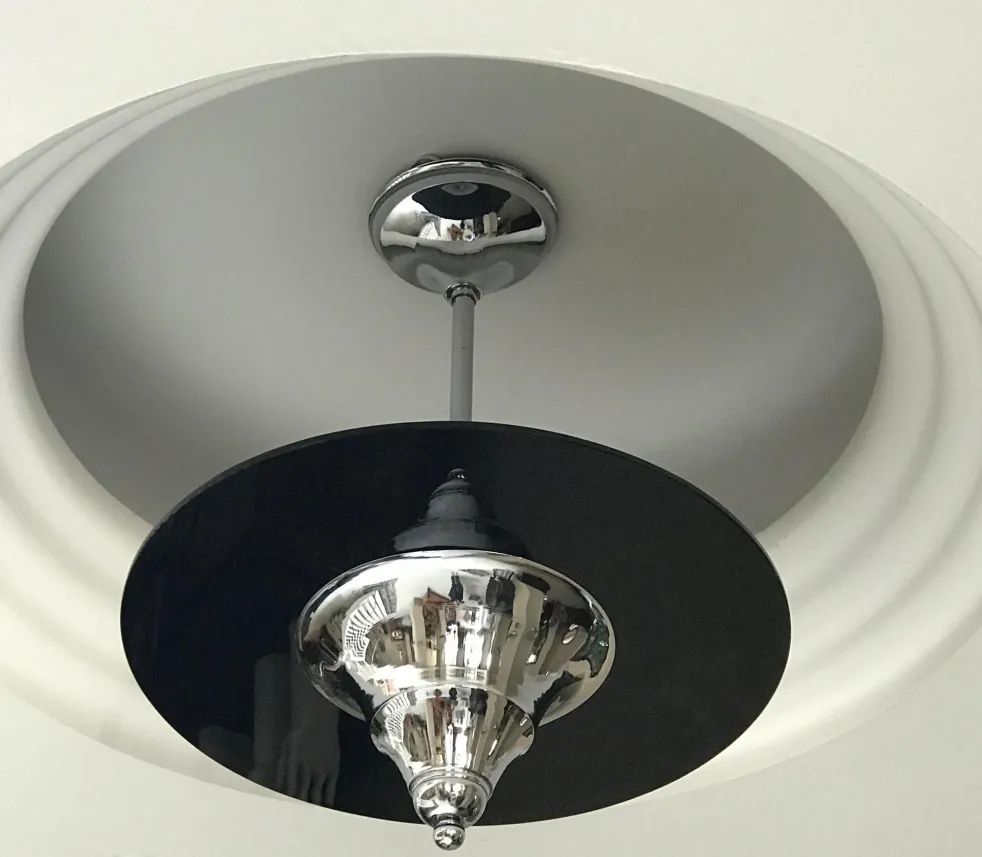 Lámpara de techo antigua con base brillante en un ambiente moderno.