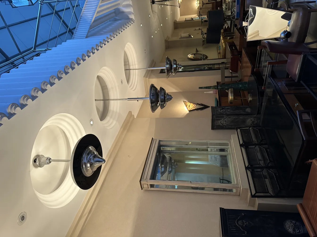 Lampada a sospensione antica, elegante, in un ambiente decorativo. Vari mobili intorno.