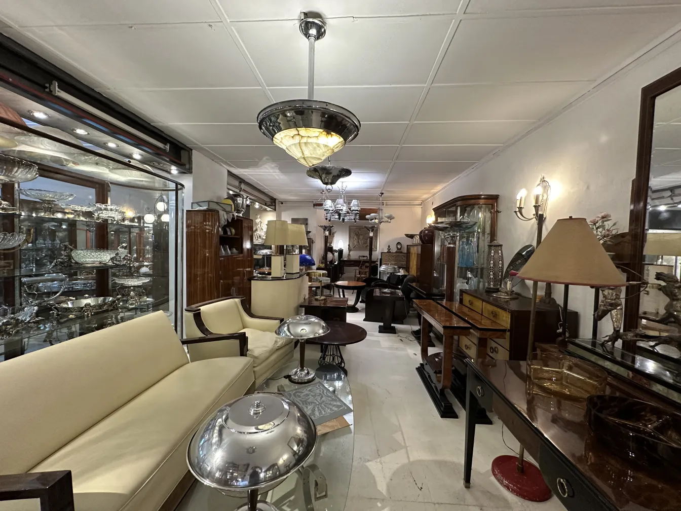 Lámpara de techo antigua rodeada de muebles clásicos en una tienda