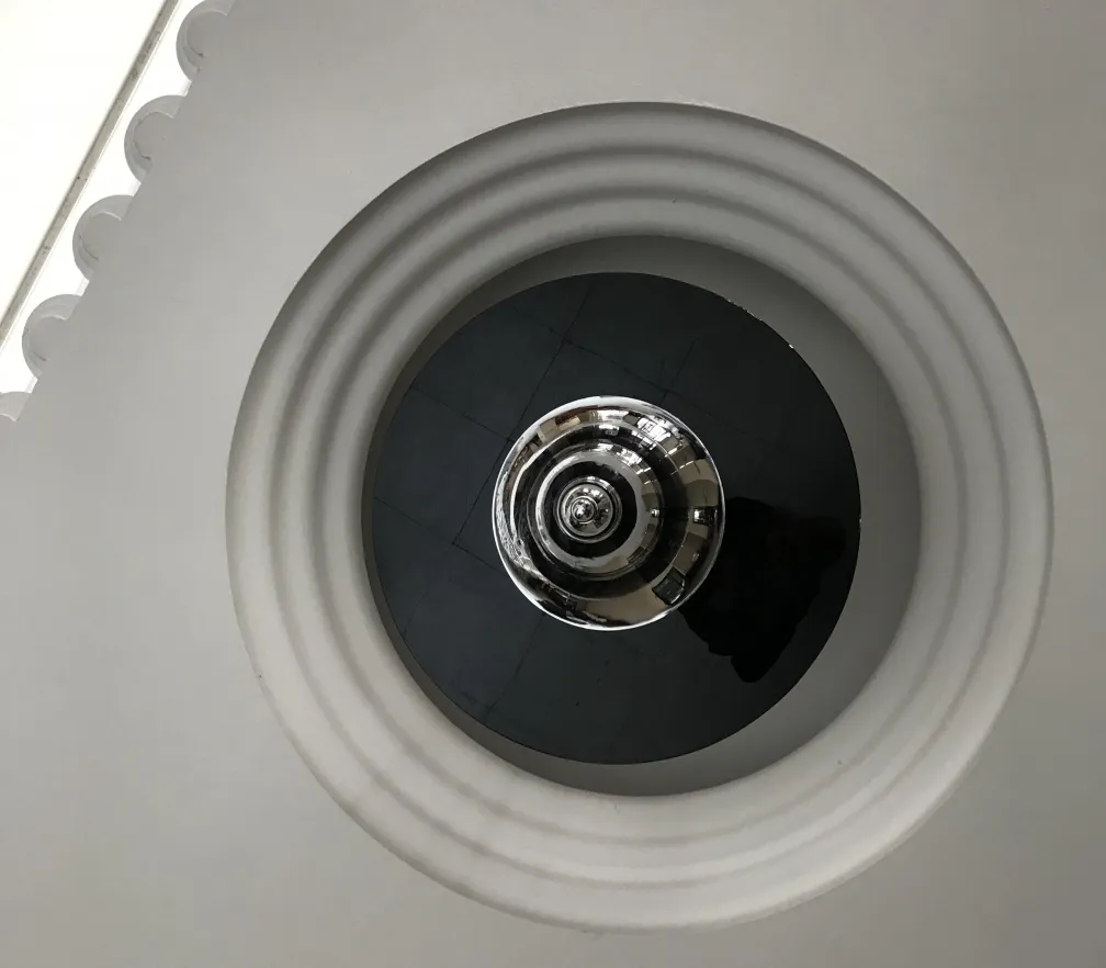 Lampada a sospensione antica con design circolare elegante.