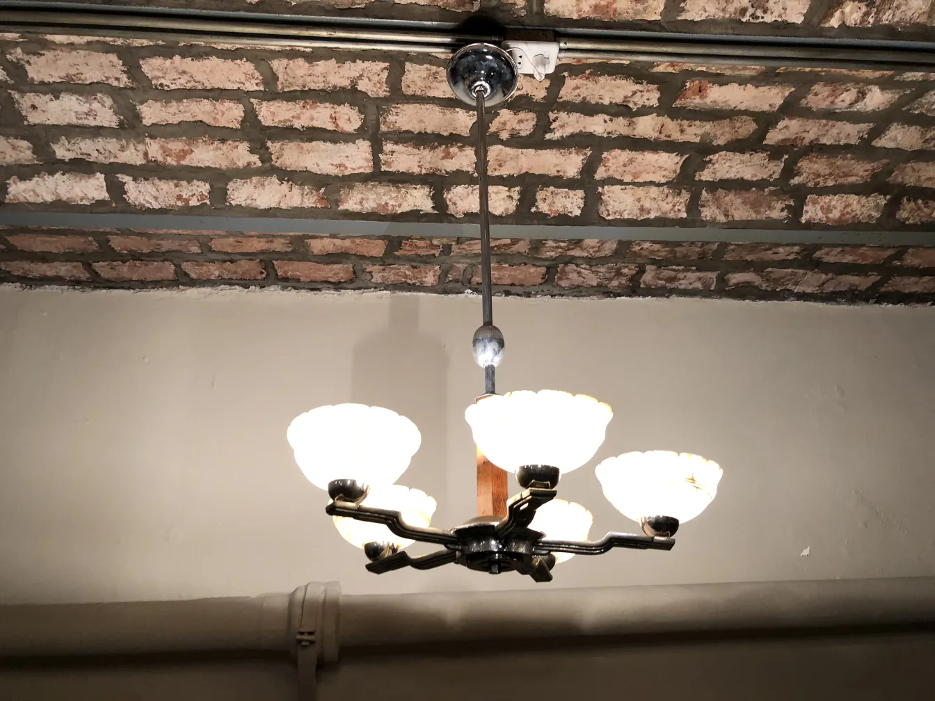 Lámpara de techo antigua con luces blancas en ambientación rústica.