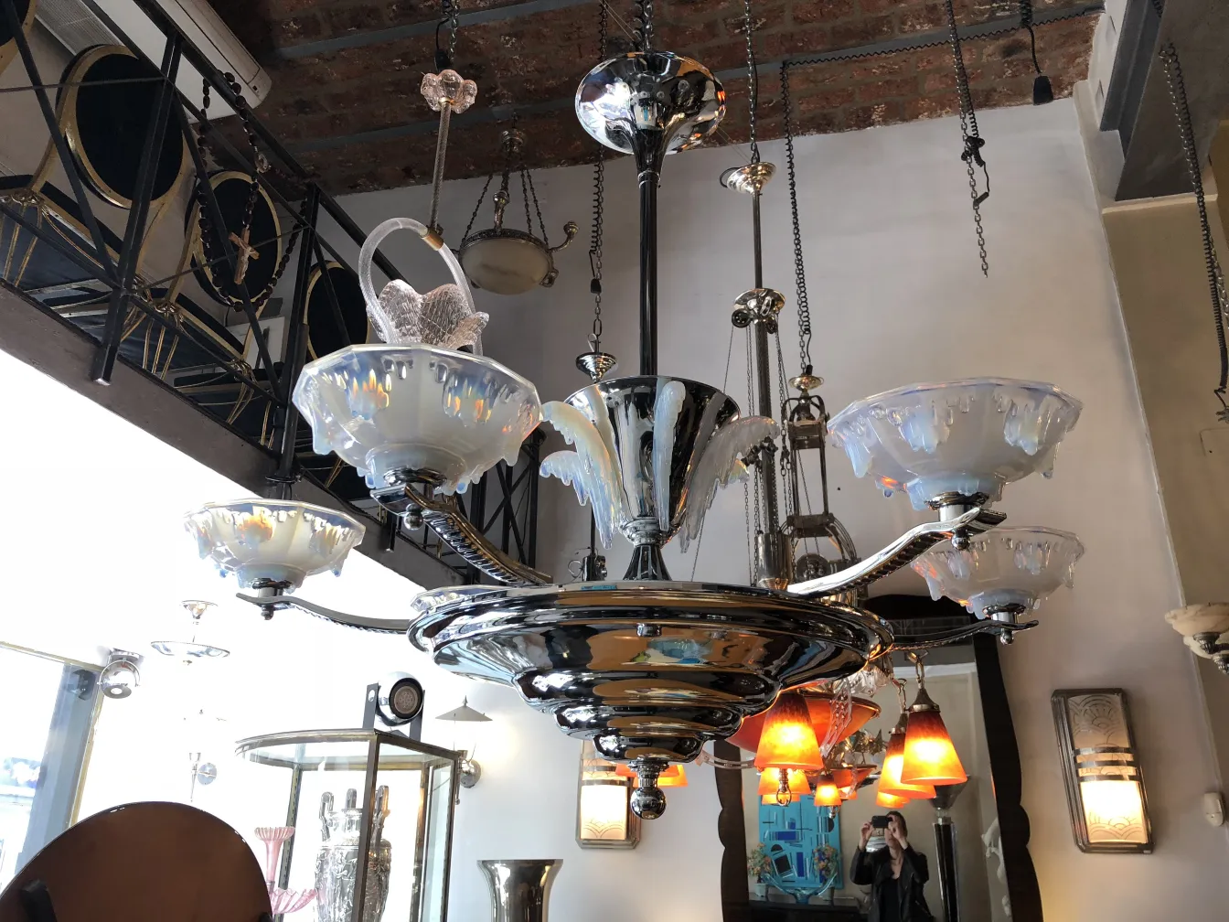 Lampada a sospensione antica con finitura lucida e dettagli decorativi.