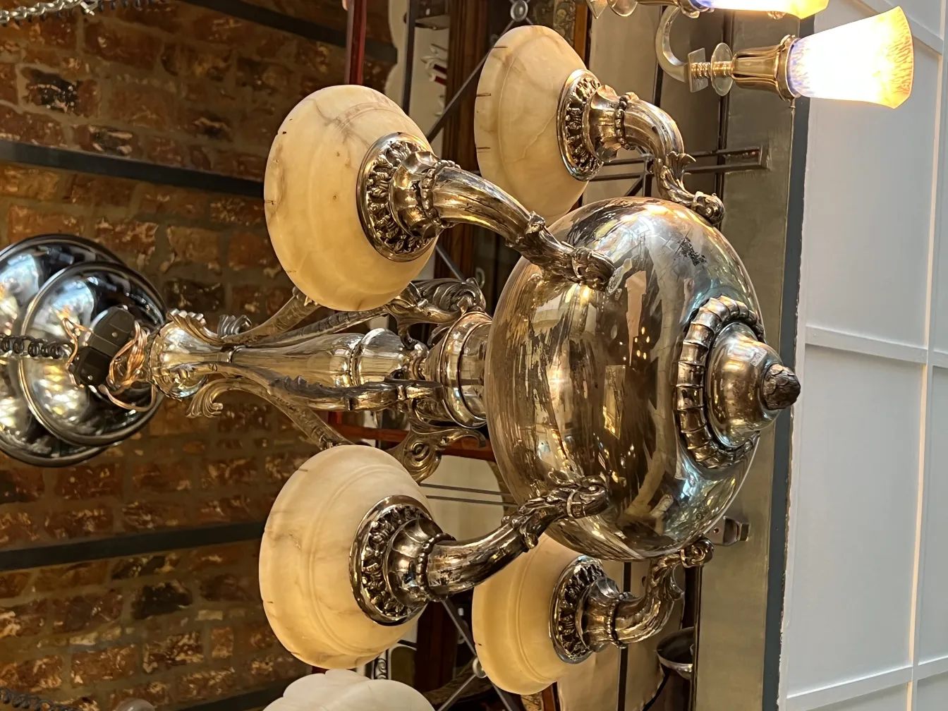 Lampada a sospensione antica con dettagli decorativi e luci brillanti, ambiente elegante.