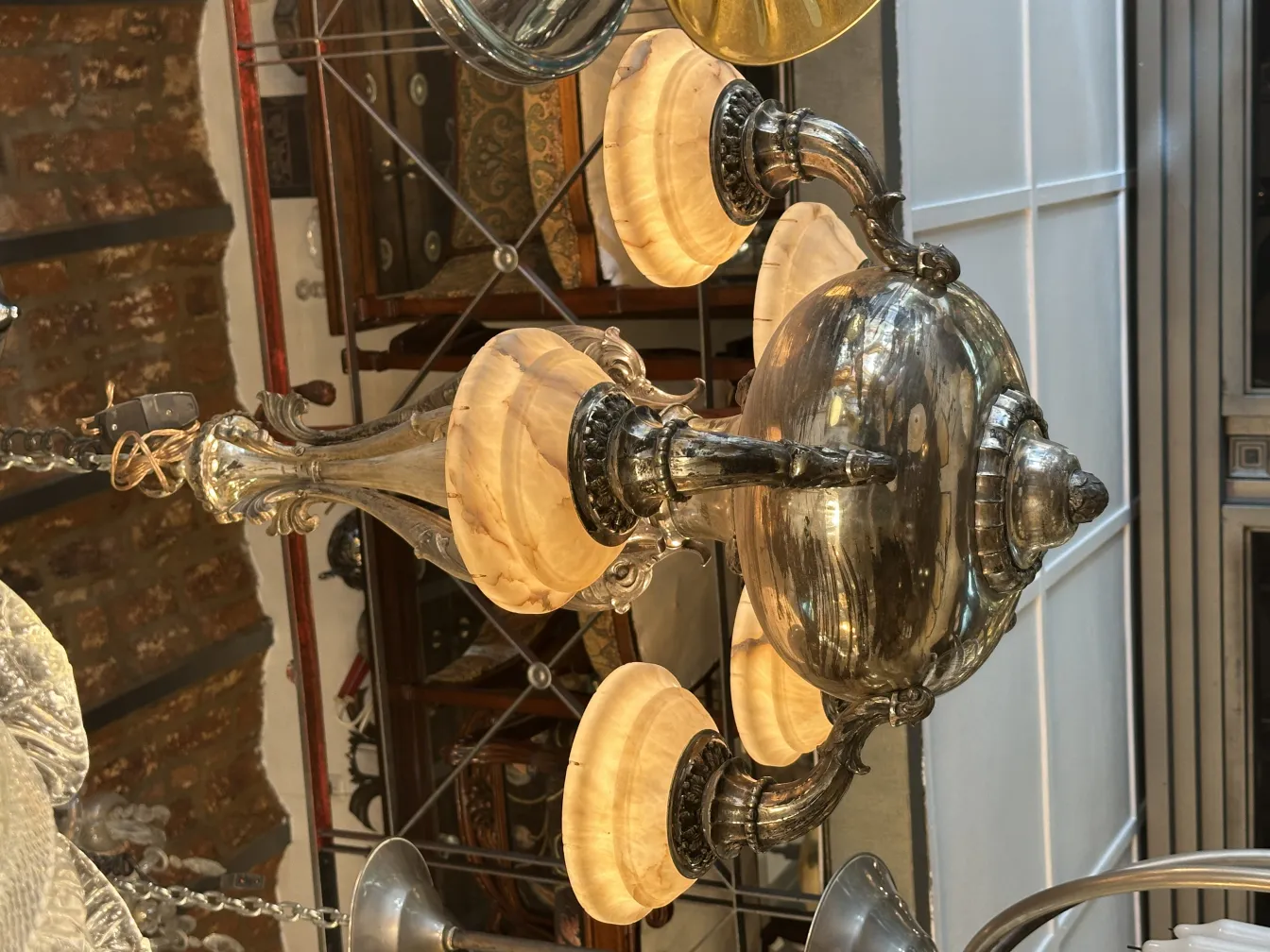 Antique hanging lamp with ornate arms and glowing shades