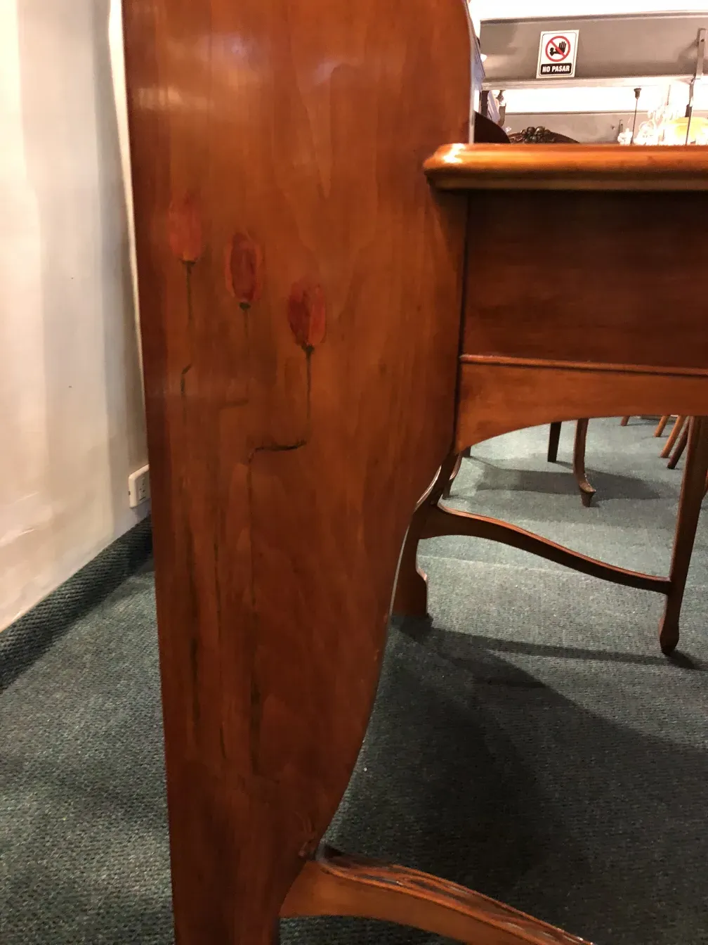 escritorio antiguo con detalles de flores en la parte superior