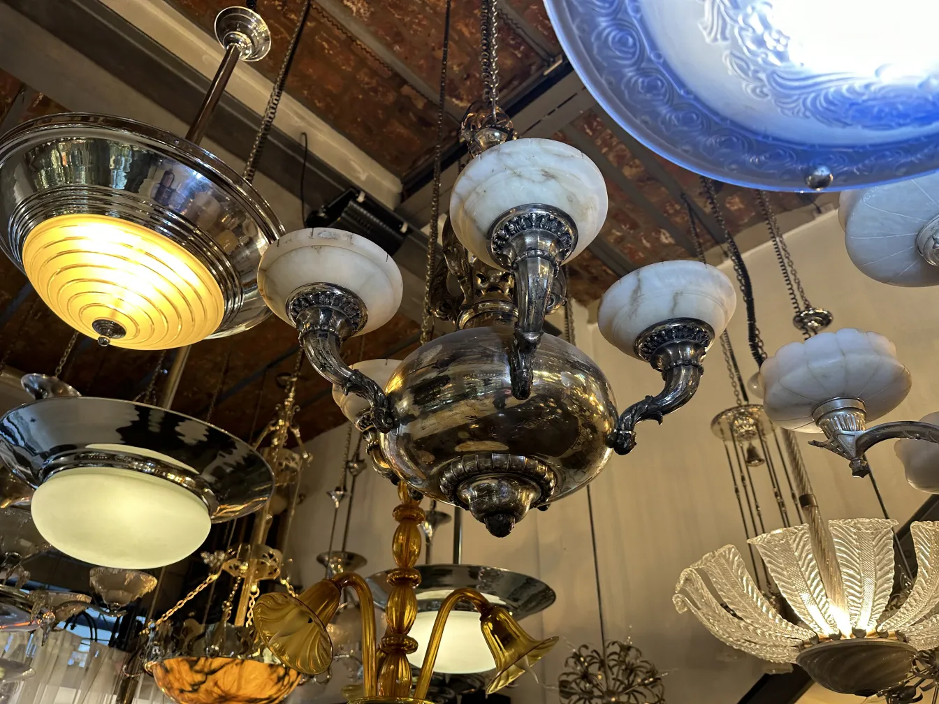 Lámpara de techo antigua con bombillas y detalles decorativos en un ambiente cálido.