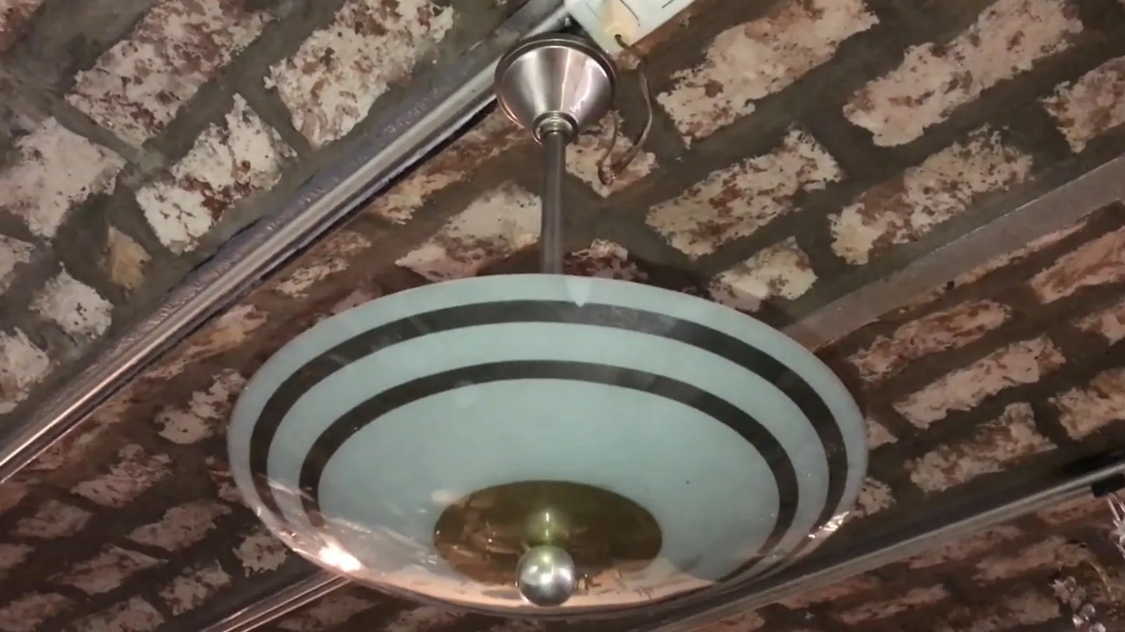 Lámpara de techo antigua con diseño elegante, en ambiente rústico.