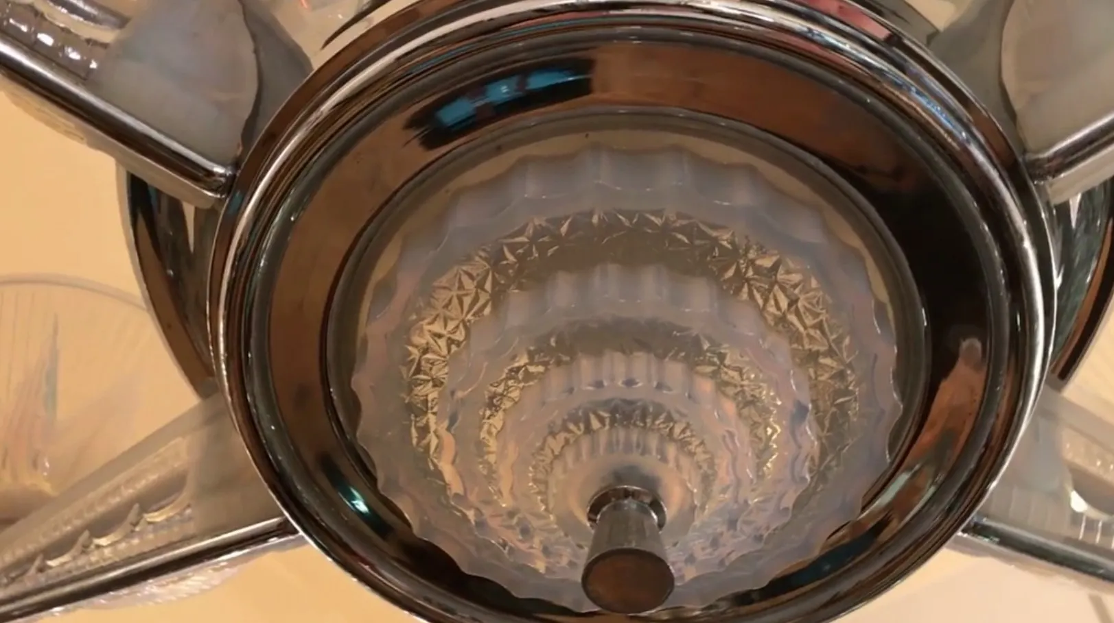 Lámpara de techo antigua con diseño brillante y elegante en plata, ambiente acogedor.