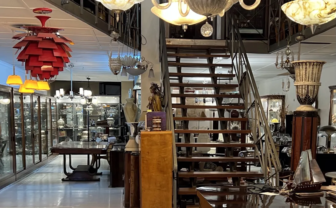 Lampada a sospensione antica con design colorato in un negozio di antiquariato.