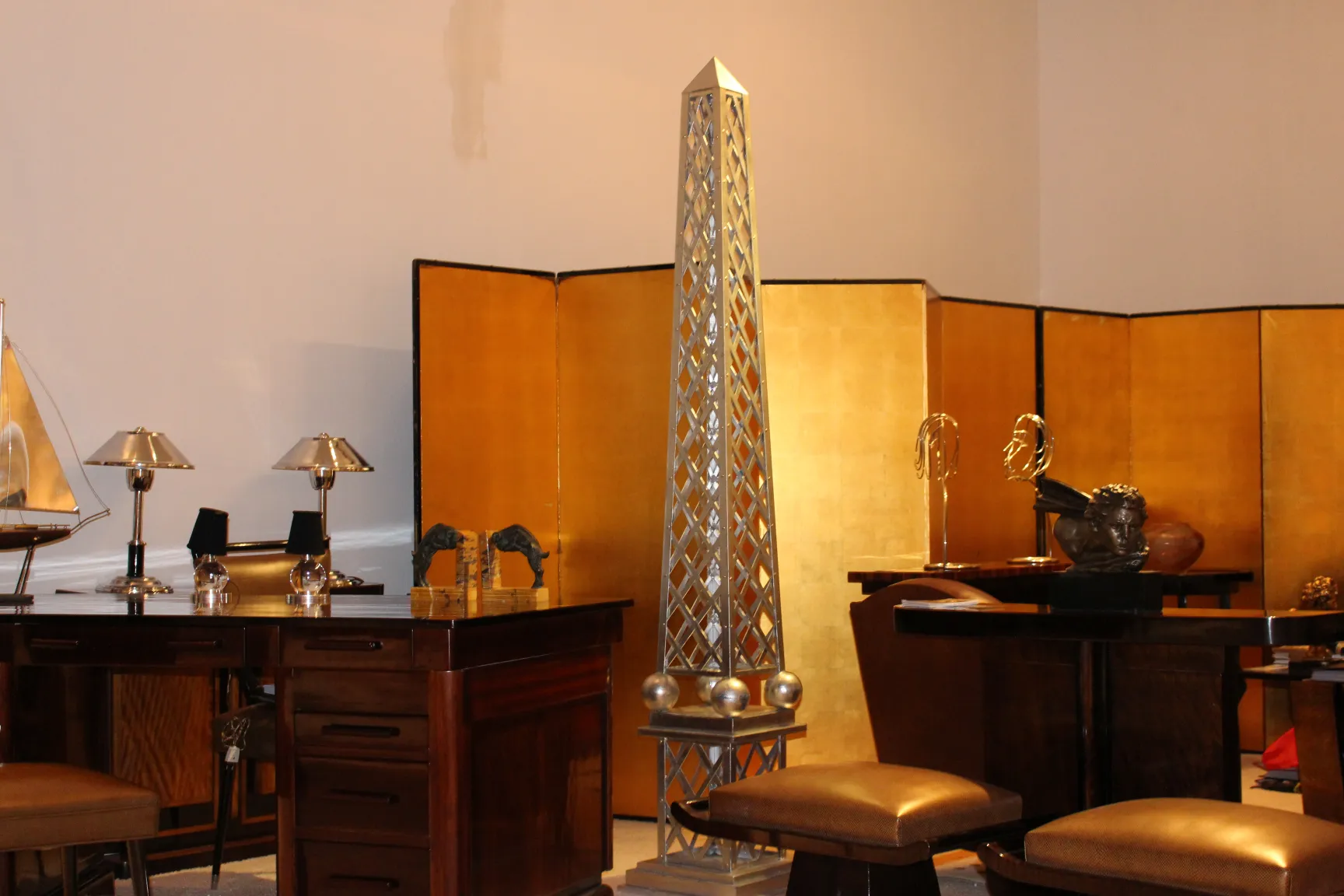 Escritorio antiguo de madera en ambiente elegante con lámparas y decoraciones.