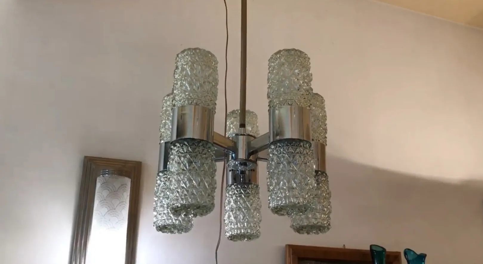 Lâmpada de teto antiga com estrutura metálica brilhante e abajures de vidro facetado, ideal para iluminação da casa.