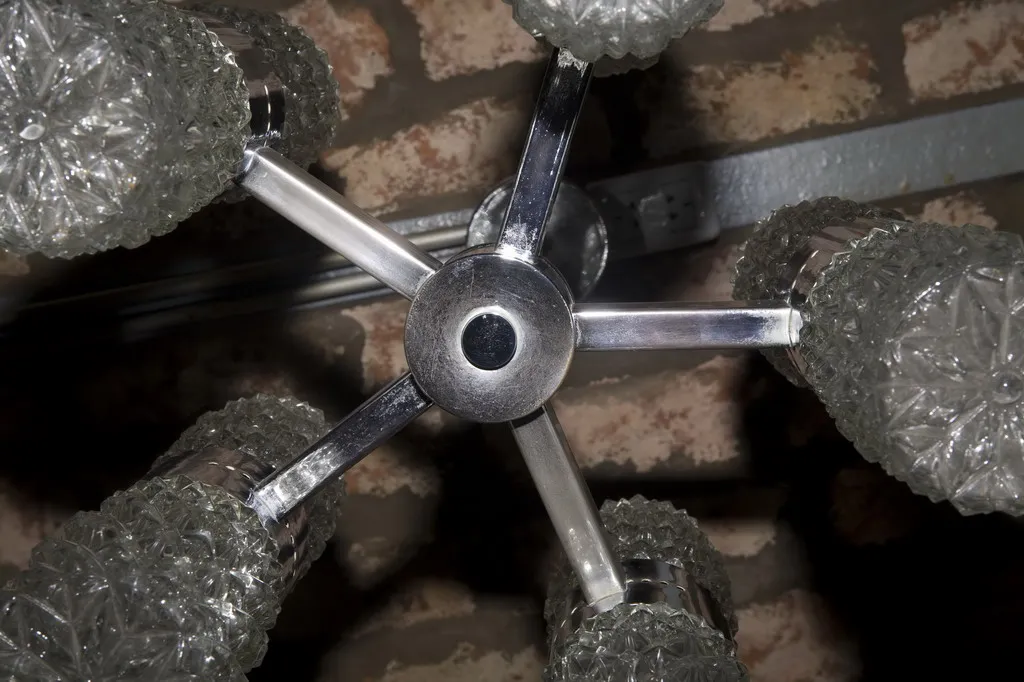 Detalhes de uma lâmpada de teto antiga com cristal brilhante em um ambiente acolhedor.