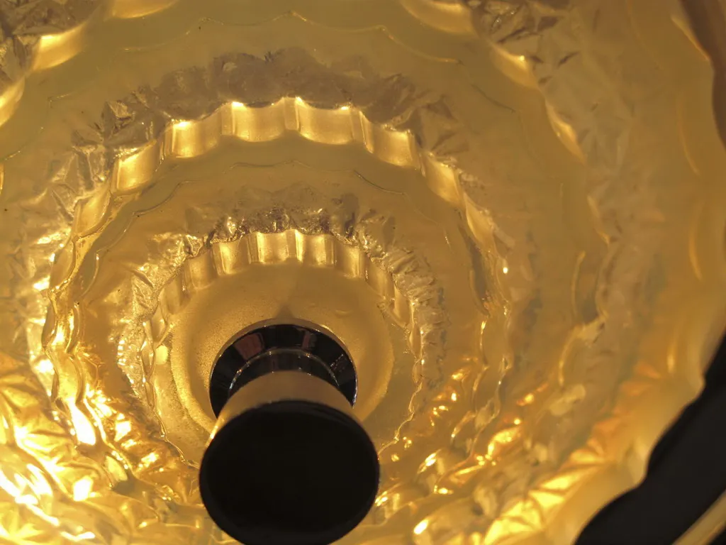 Antike Hängelampe mit einzigartigem Design und glänzendem goldenen Licht.