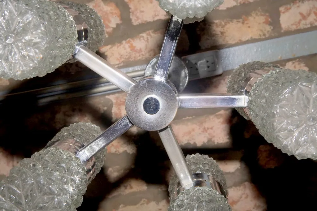 Lámpara de techo antigua con cristales decorativos, vista desde abajo, ambiente rústico.