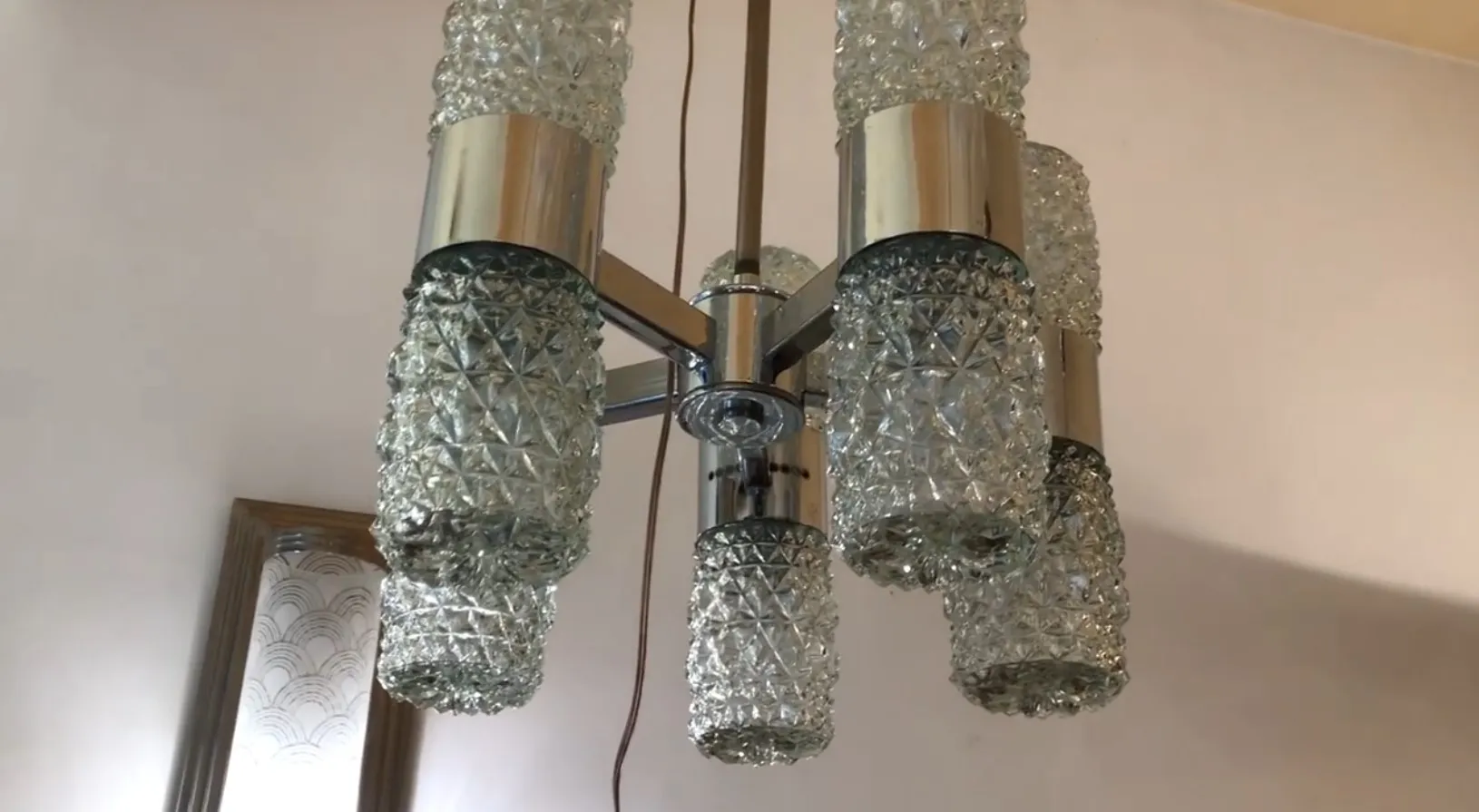 Lustre ancien avec des cristaux décoratifs dans un cadre classique.