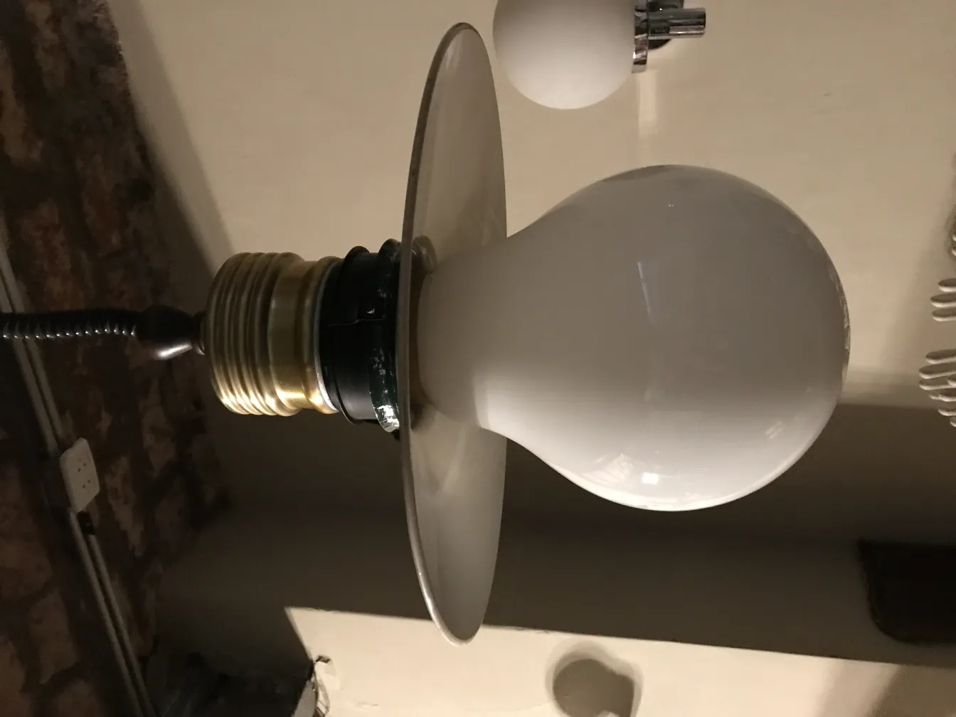 Lustre antique avec une forme sphérique et une base élégante.