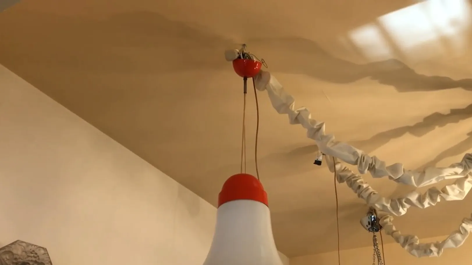 लटकता हुआ दीपक प्राचीन लाल और सफेद डिज़ाइन में, आरामदायक वातावरण में।