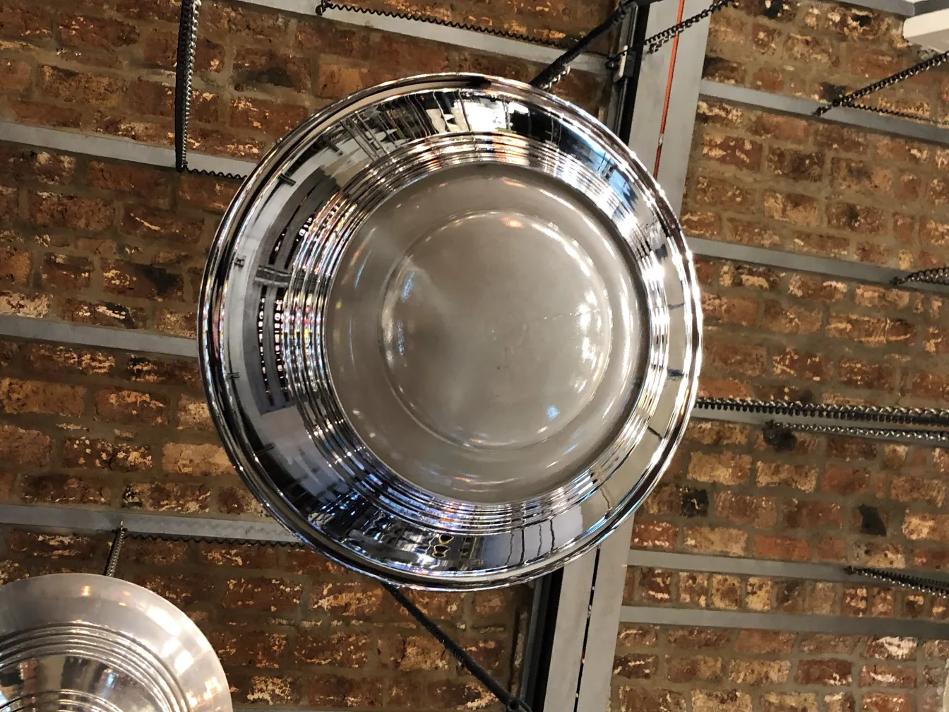 Antike Hängelampe mit glänzender Oberfläche, elegantes Design in rustikalem Ambiente.