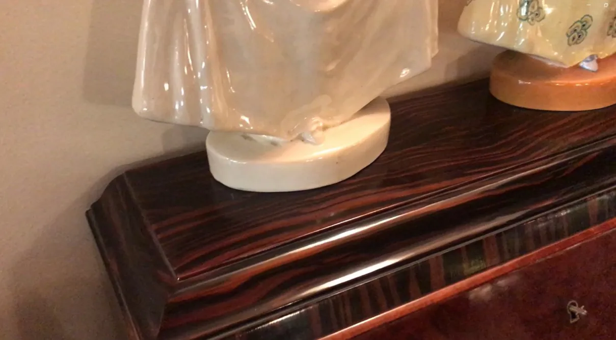 Escritorio antiguo con esculturas decorativas en la parte superior.