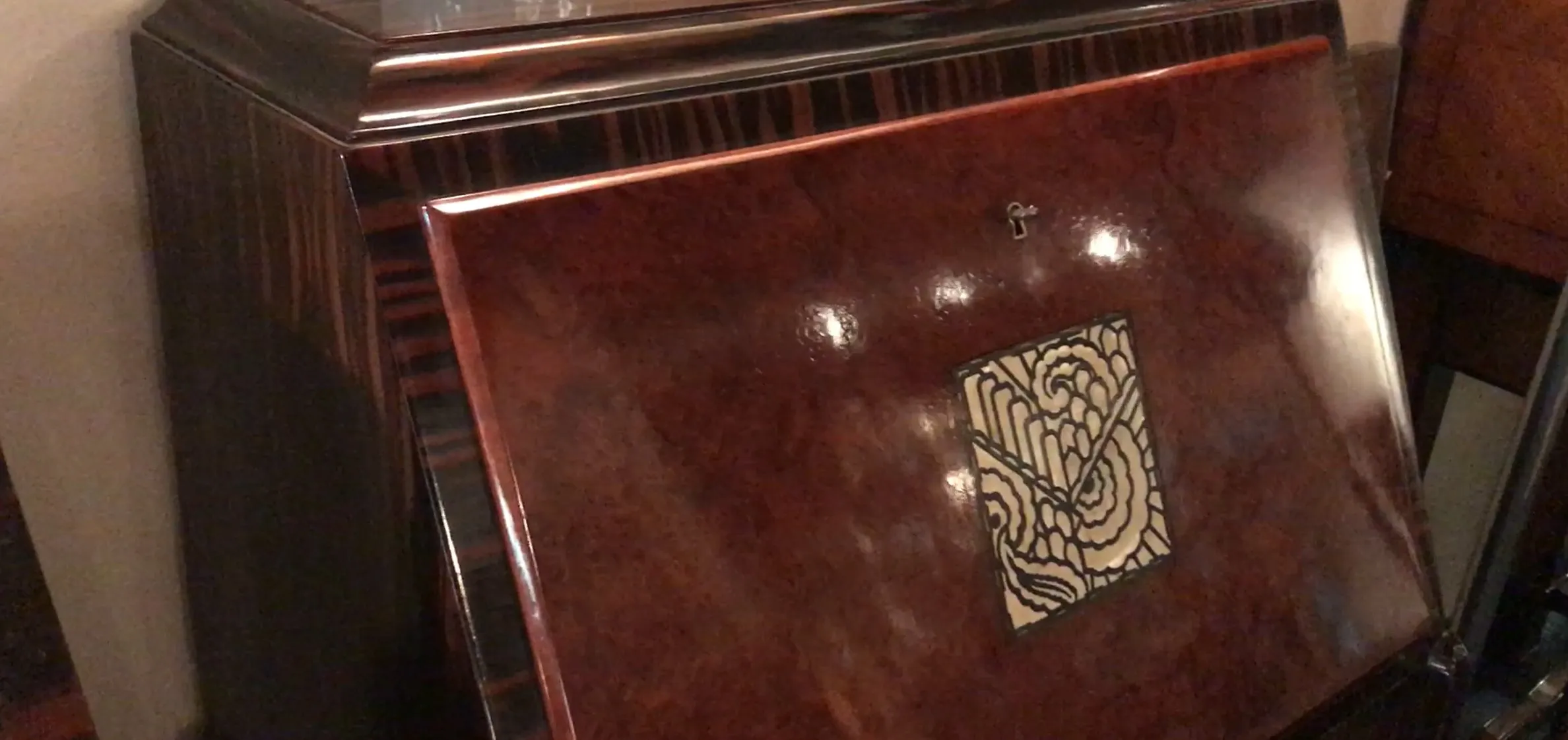 Escritorio antiguo de madera con diseño decorativo en la tapa, ambiente clásico.