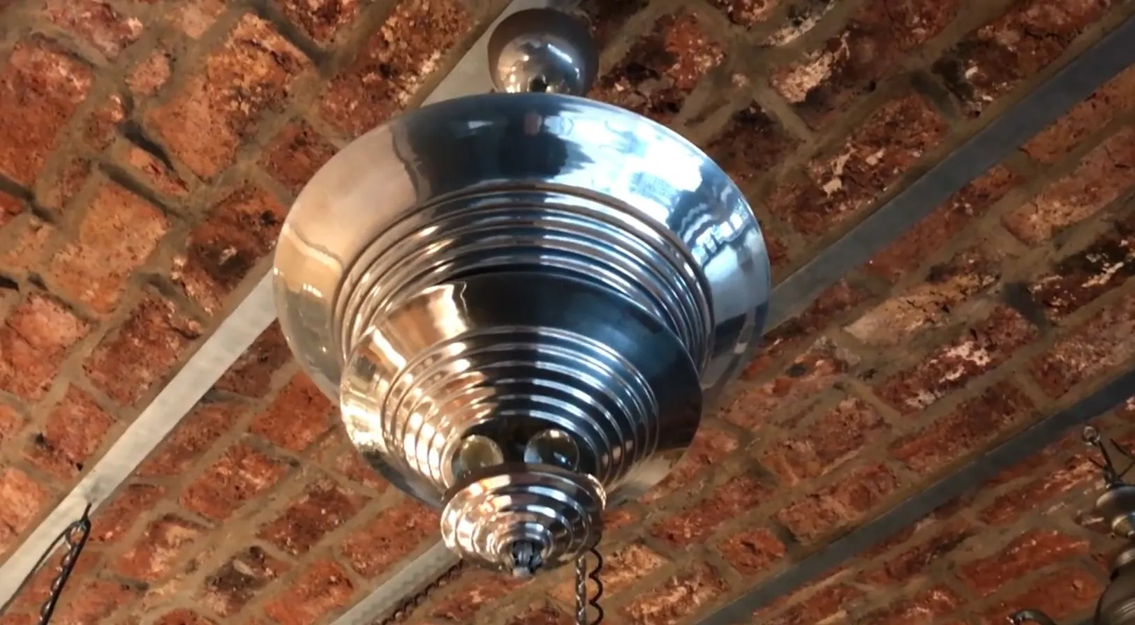 Lustre ancien avec design brillant dans un cadre de brique