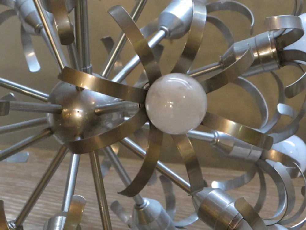 Antike Hängelampe mit modernem, glänzendem Metalldesign in einem eleganten Ambiente.