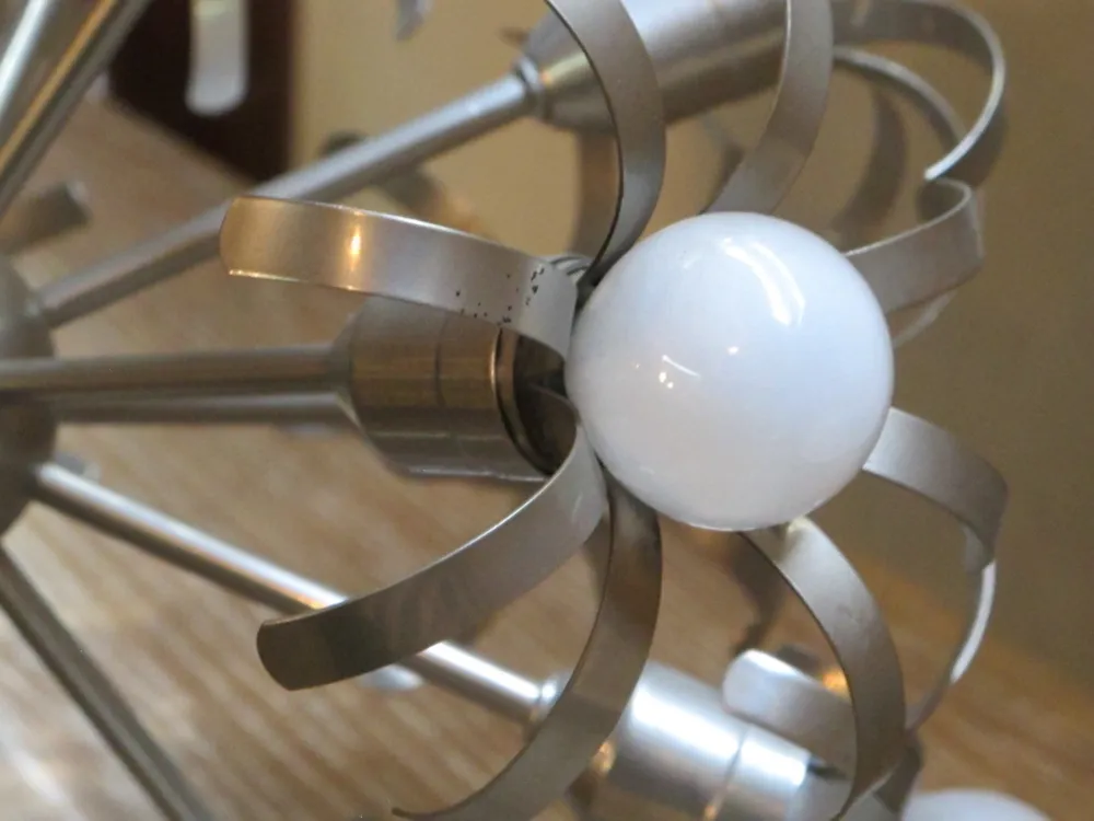 Lampada a sospensione antica con sfere bianche e design elegante.