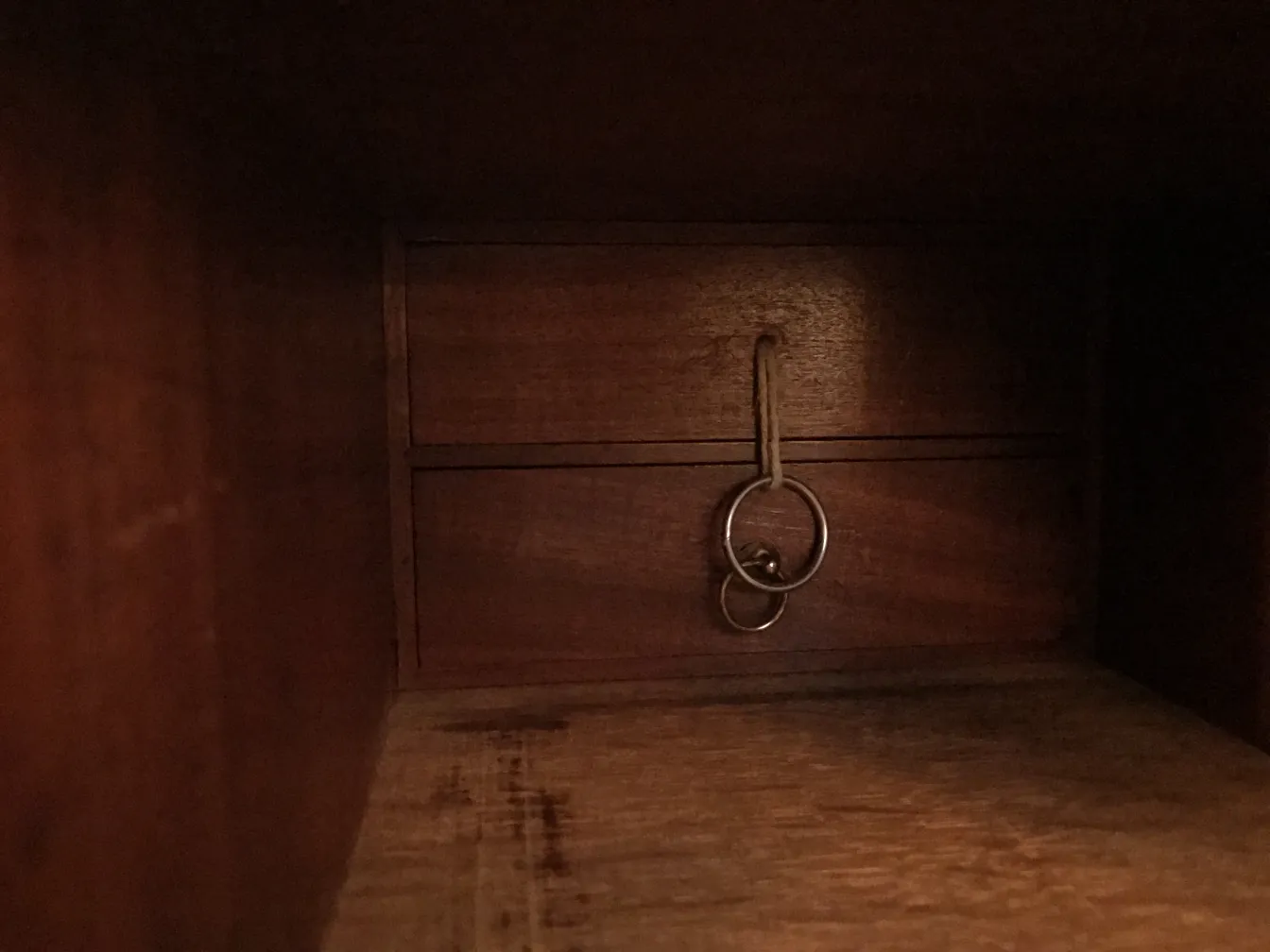 Interno di una scrivania antica con un cassetto e chiavi appese.