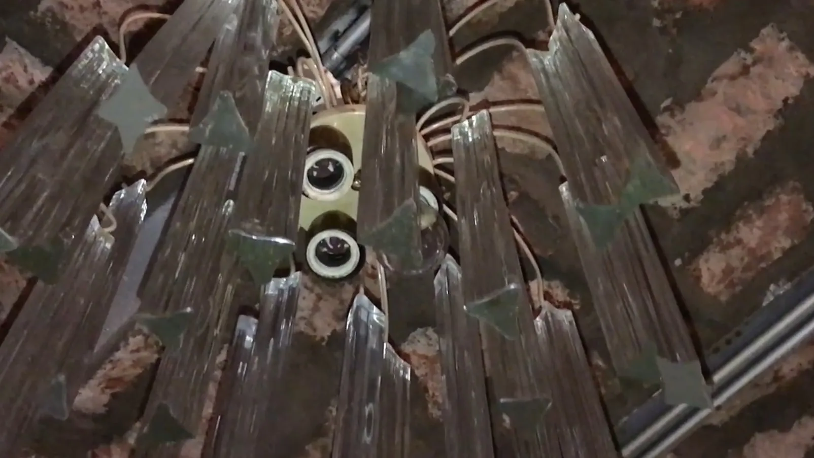 Lâmpada de teto antiga com tons translúcidos em um ambiente rústico.