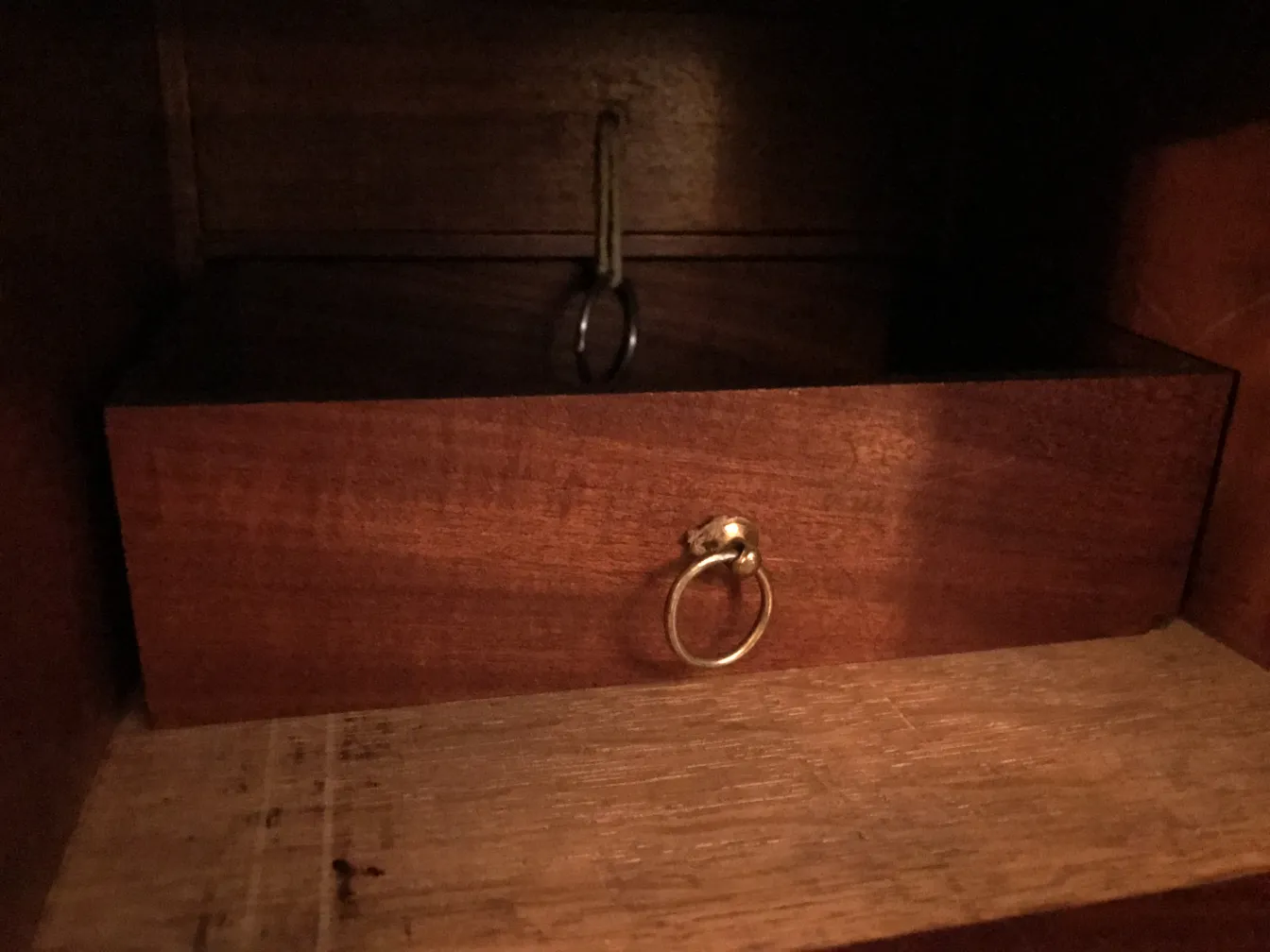 Antiker Schreibtisch mit Ringgriff und Holzoberfläche.