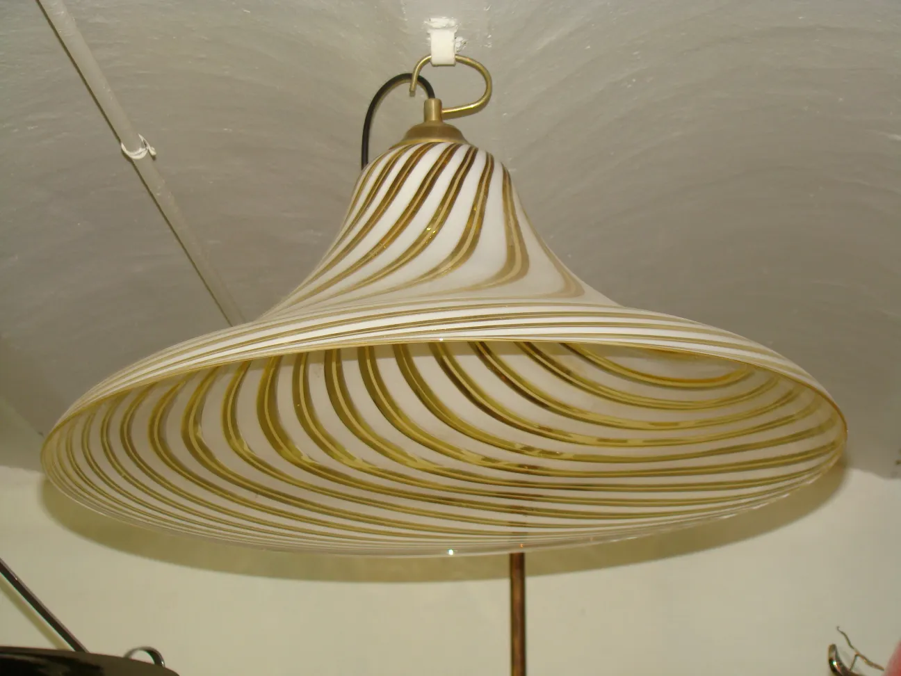 Lâmpada de teto antiga com designs geométricos e acabamento brilhante.