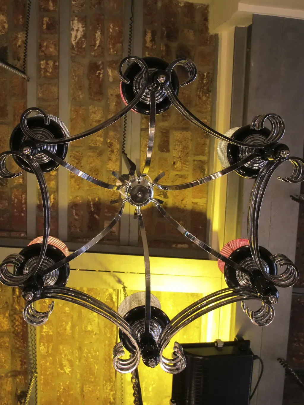 Lámpara de techo antigua con diseño elegante y luces brillantes en ambiente cálido.