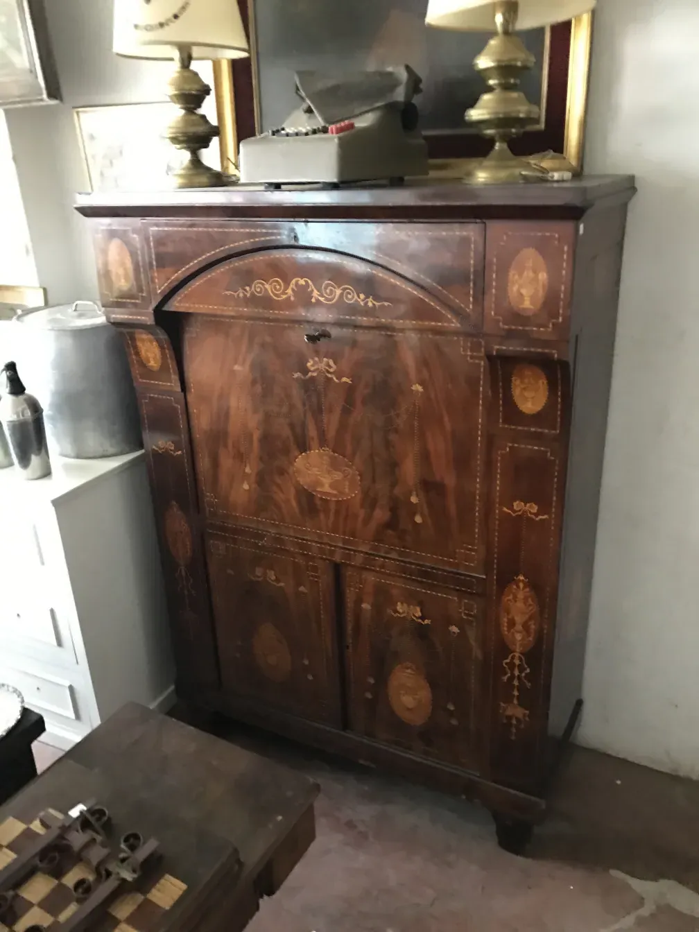 Antique wooden desk with decorative details. Set with a lamp and other desk objects.