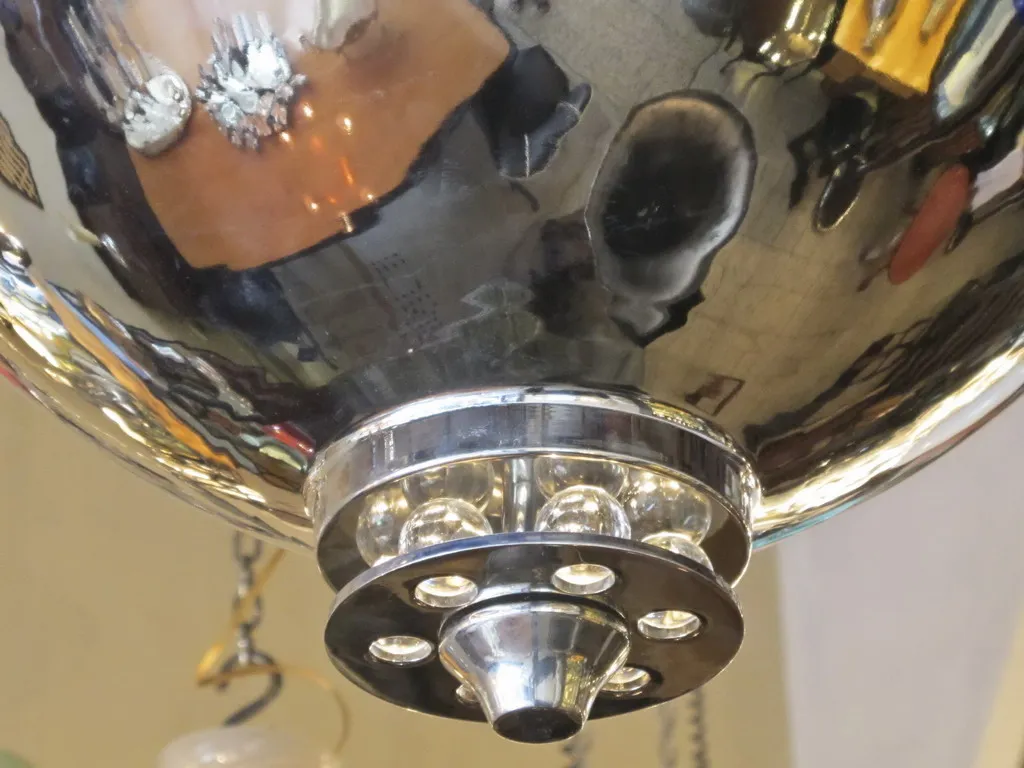 Lampada a sospensione antica con finitura lucida, in un ambiente accogliente.