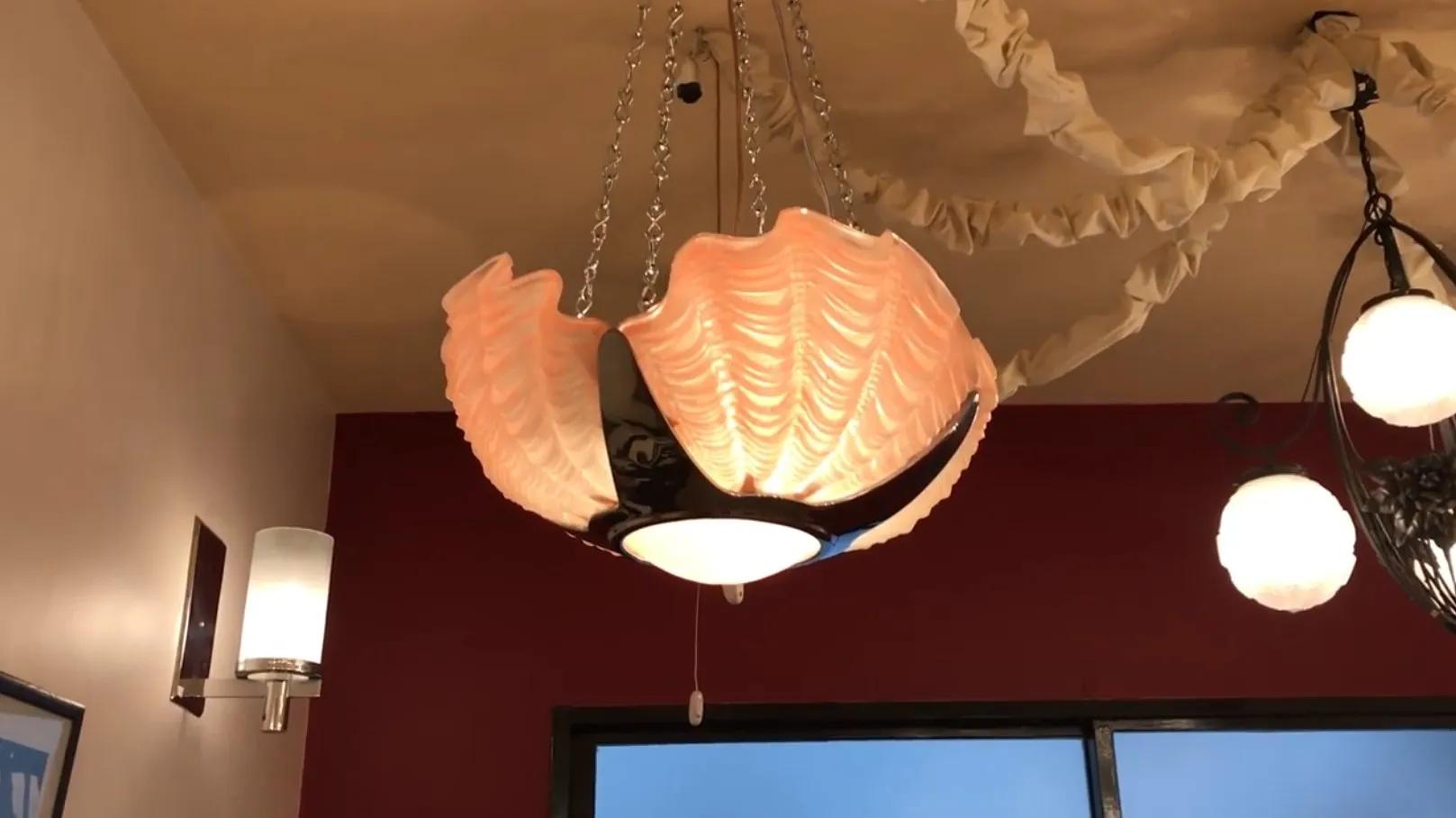 Lustre ancien couleur pastel dans un cadre décoratif.