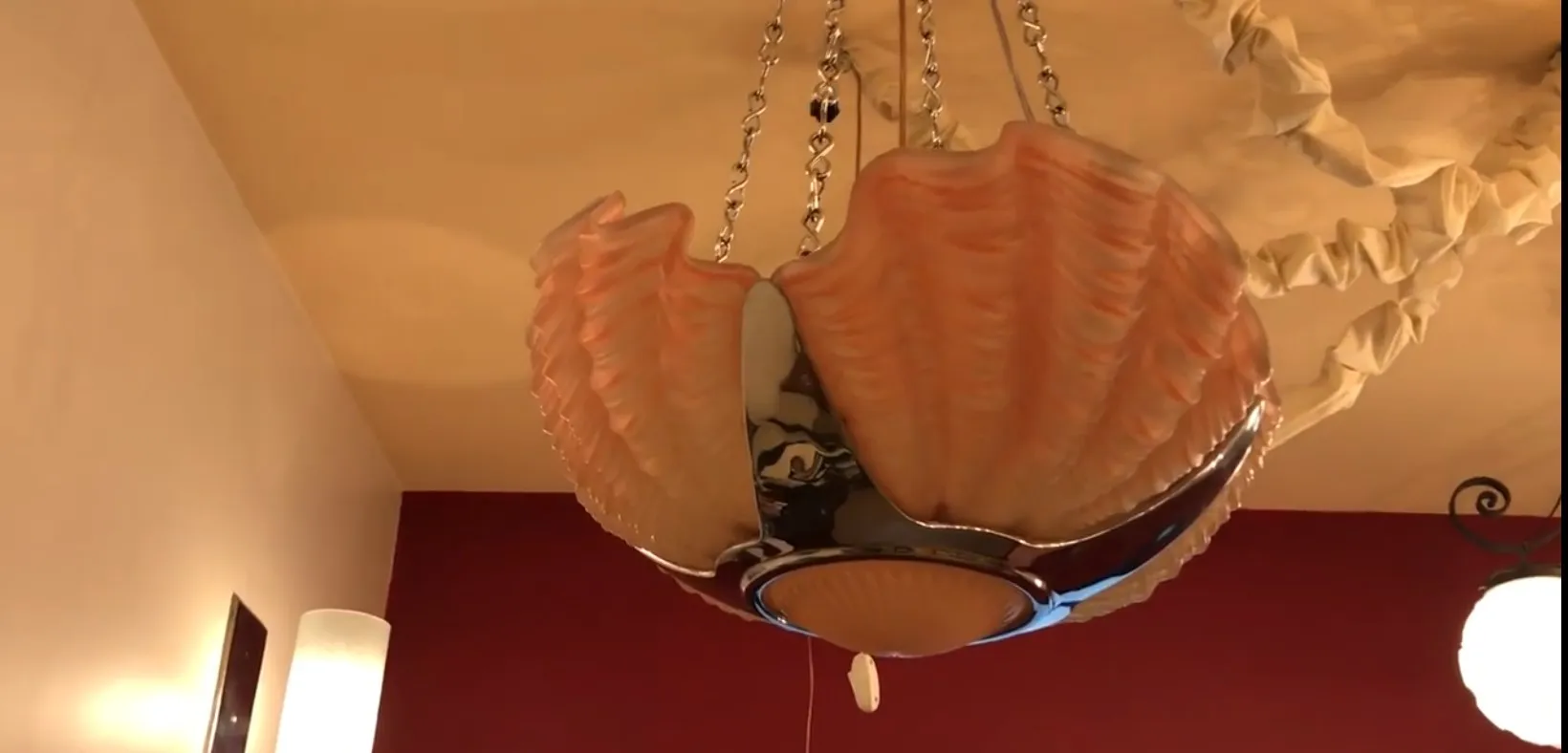 Lámpara de techo antigua con diseño de concha marina, entorno acogedor.