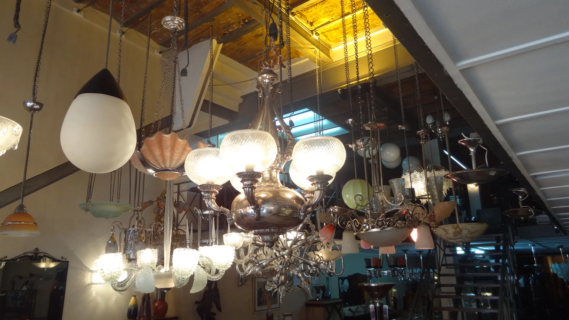 Lámpara de techo antigua con cristales brillantes y estilo decorativo, en un ambiente de luz cálida.