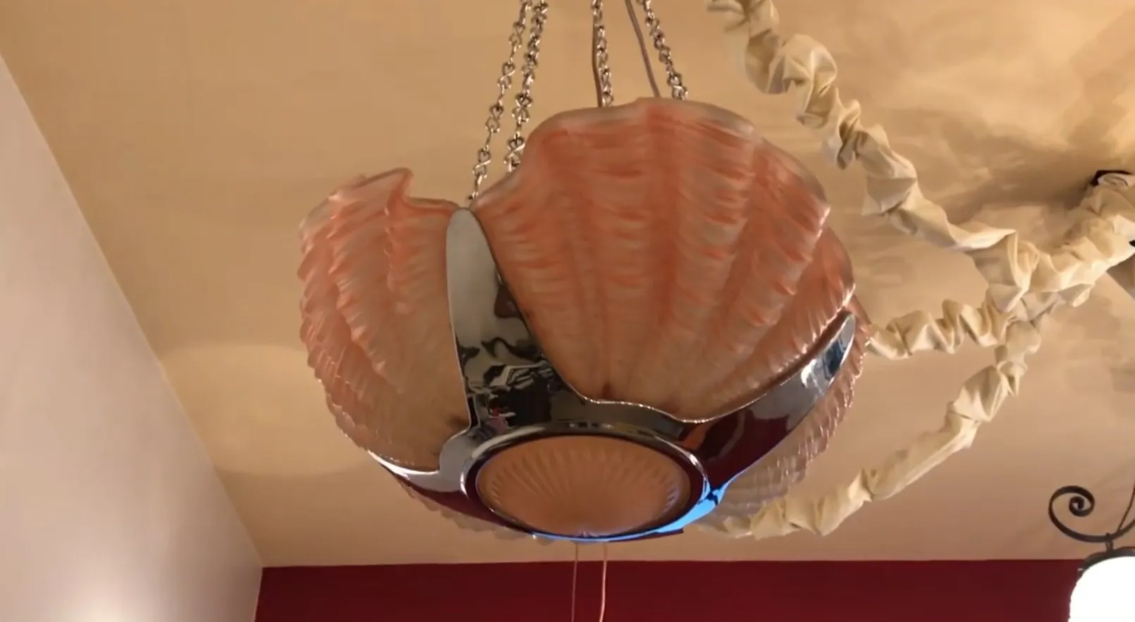 Lampada a sospensione antica a forma di conchiglia, in un'atmosfera accogliente.