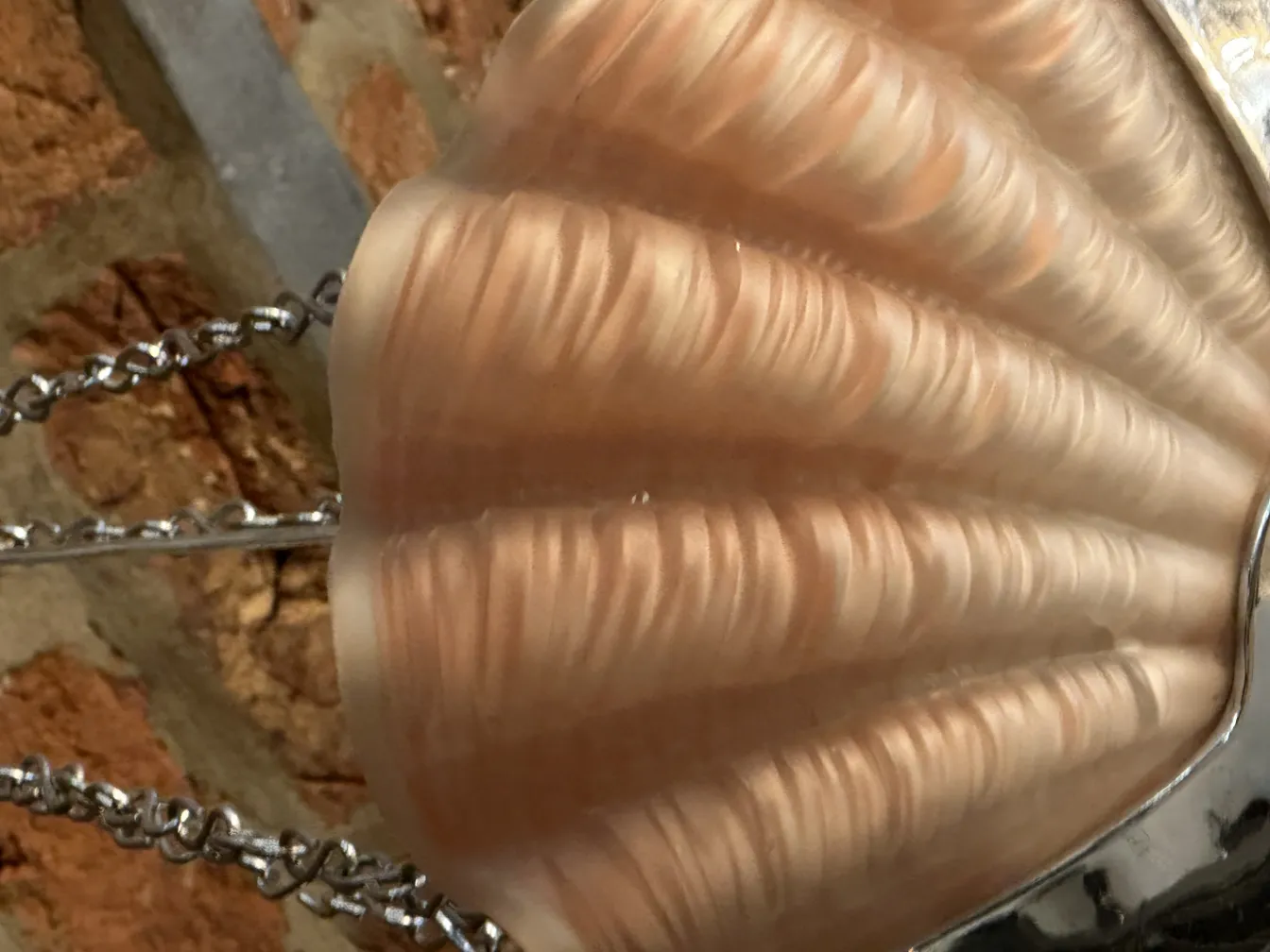 Lustre ancien avec design en coquillage, ambiance chaleureuse.