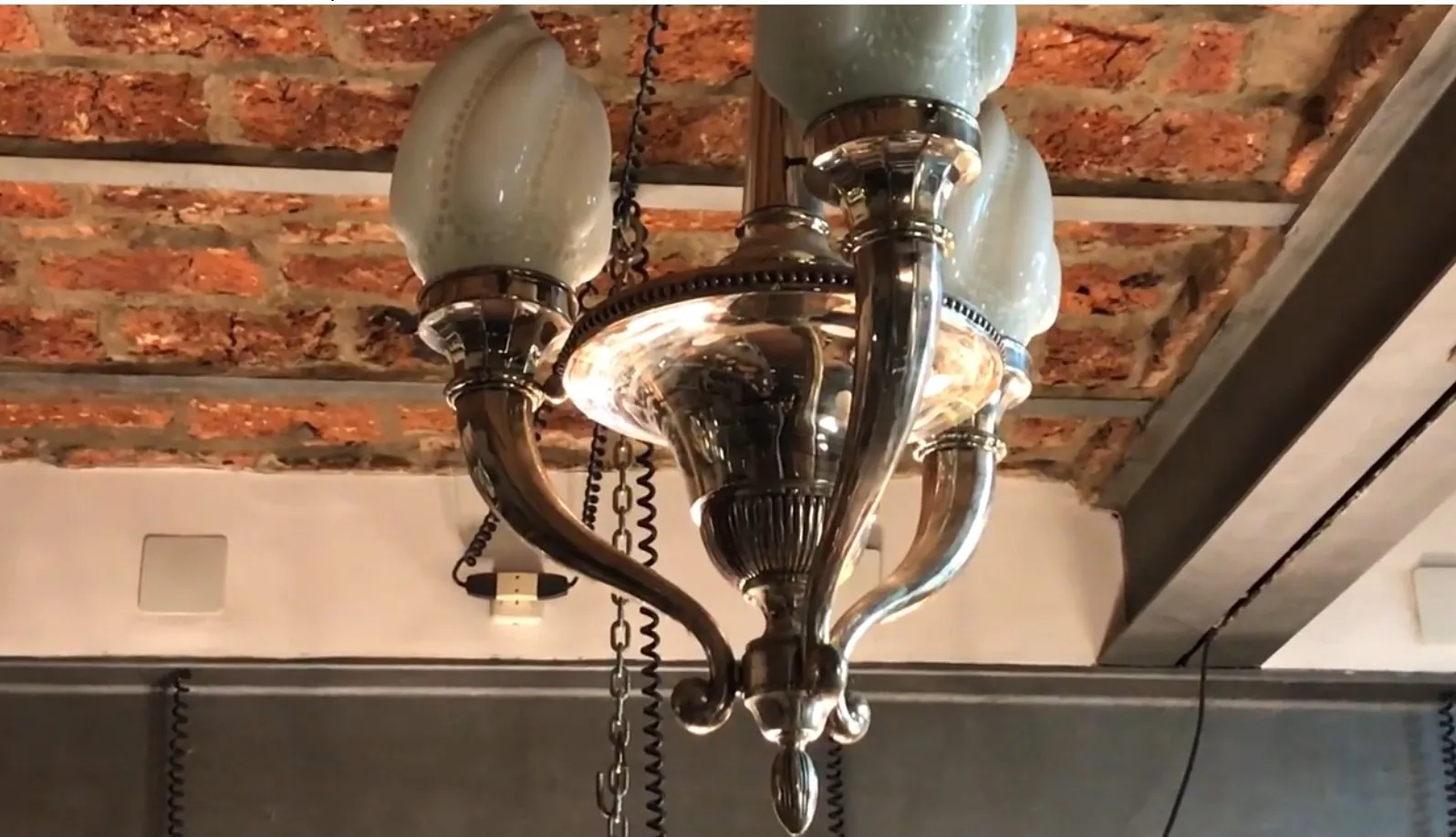 Antique hanging lamp with soft light and mint glass in a cozy setting.