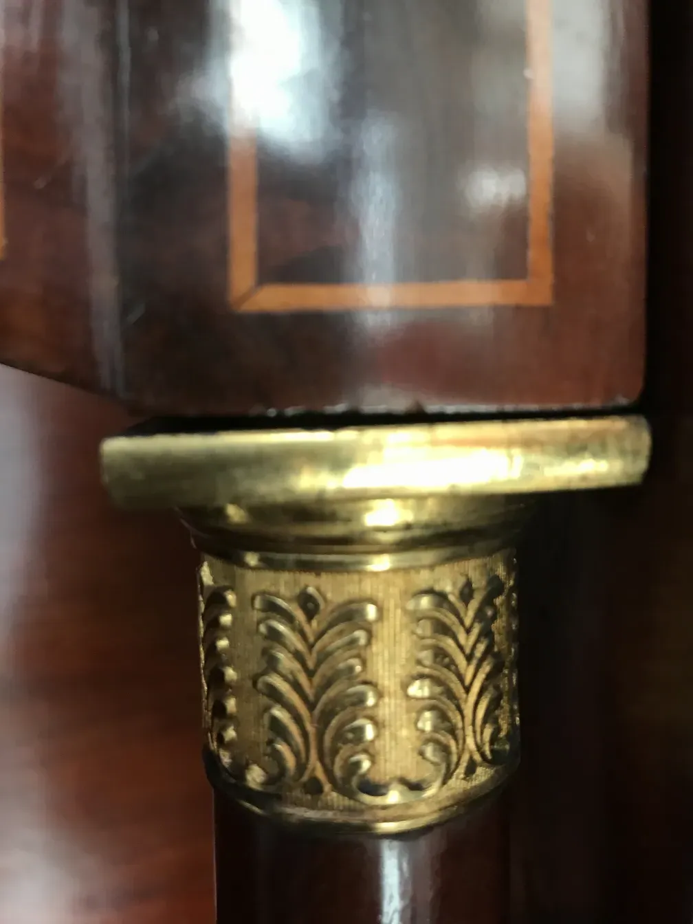 Detalles dorados en un escritorio antiguo con un acabado pulido.