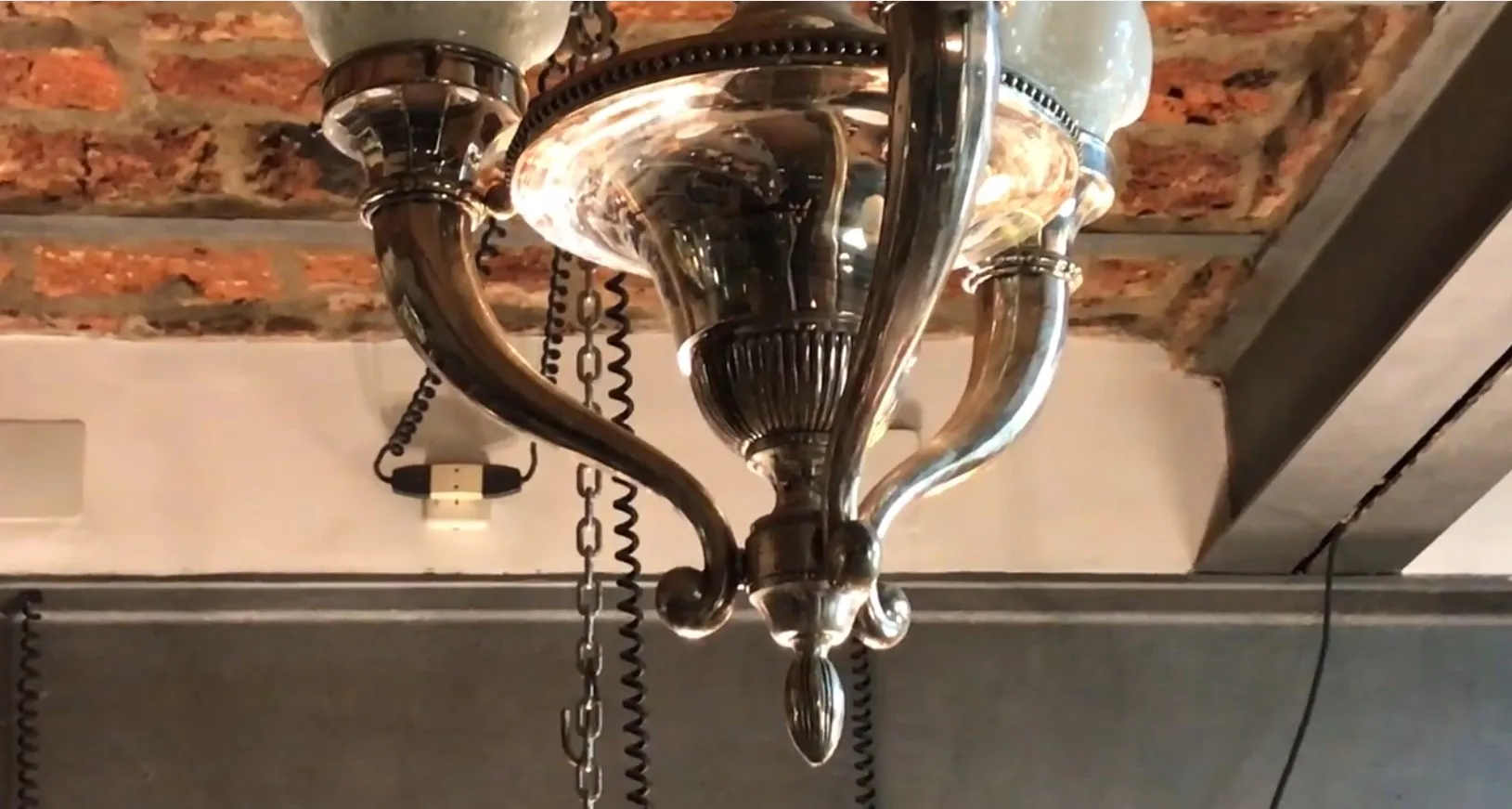 Lámpara de techo antigua con un diseño elegante y decorativo, colgando en un ambiente acogedor.