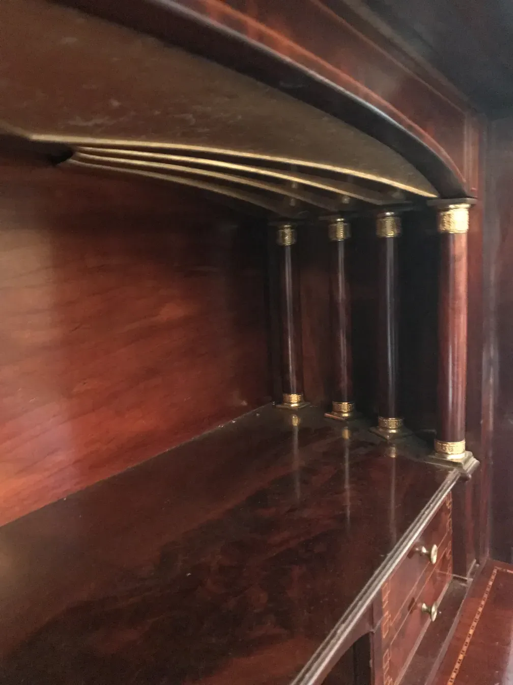 Interior view of an antique desk with partitions and ornamental detailing.