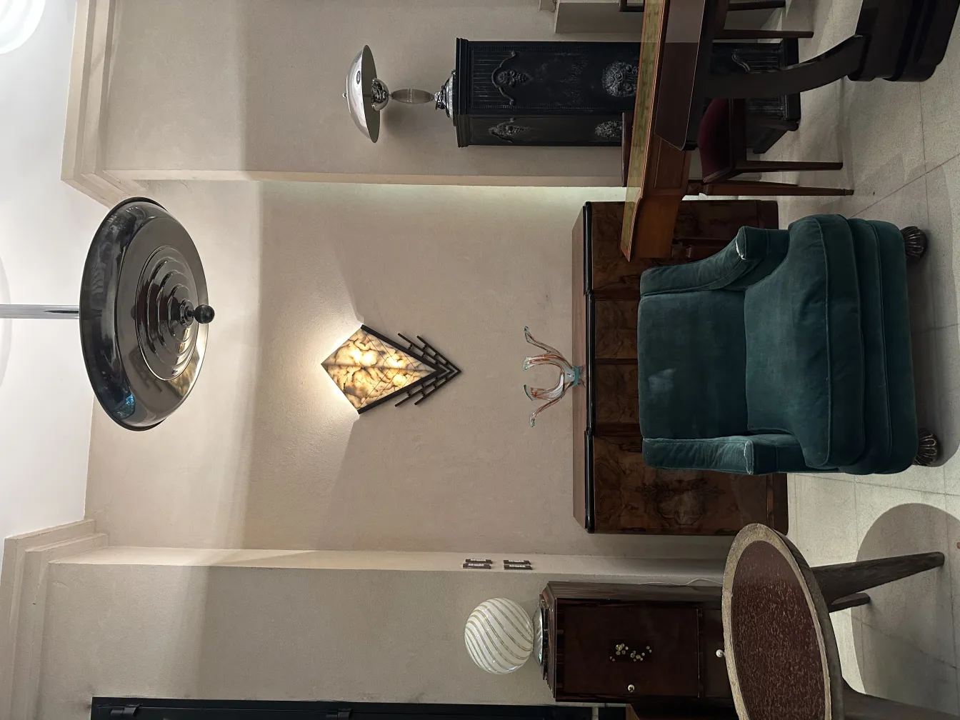 Antique hanging lamp with a shiny metal finish in a lit room.