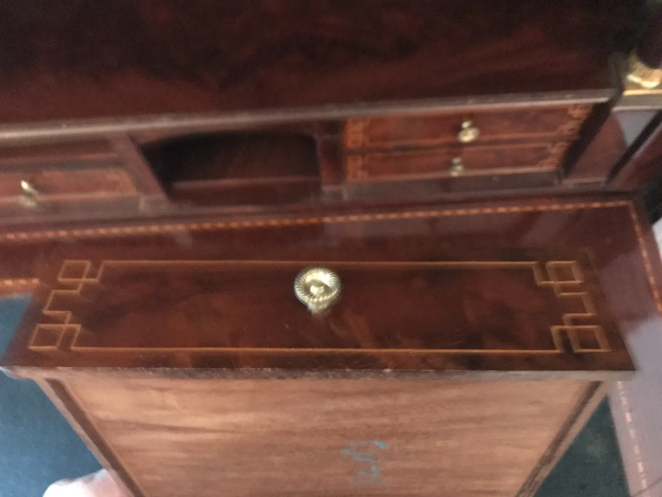 Antique desk with a decorative design on top, dark background.