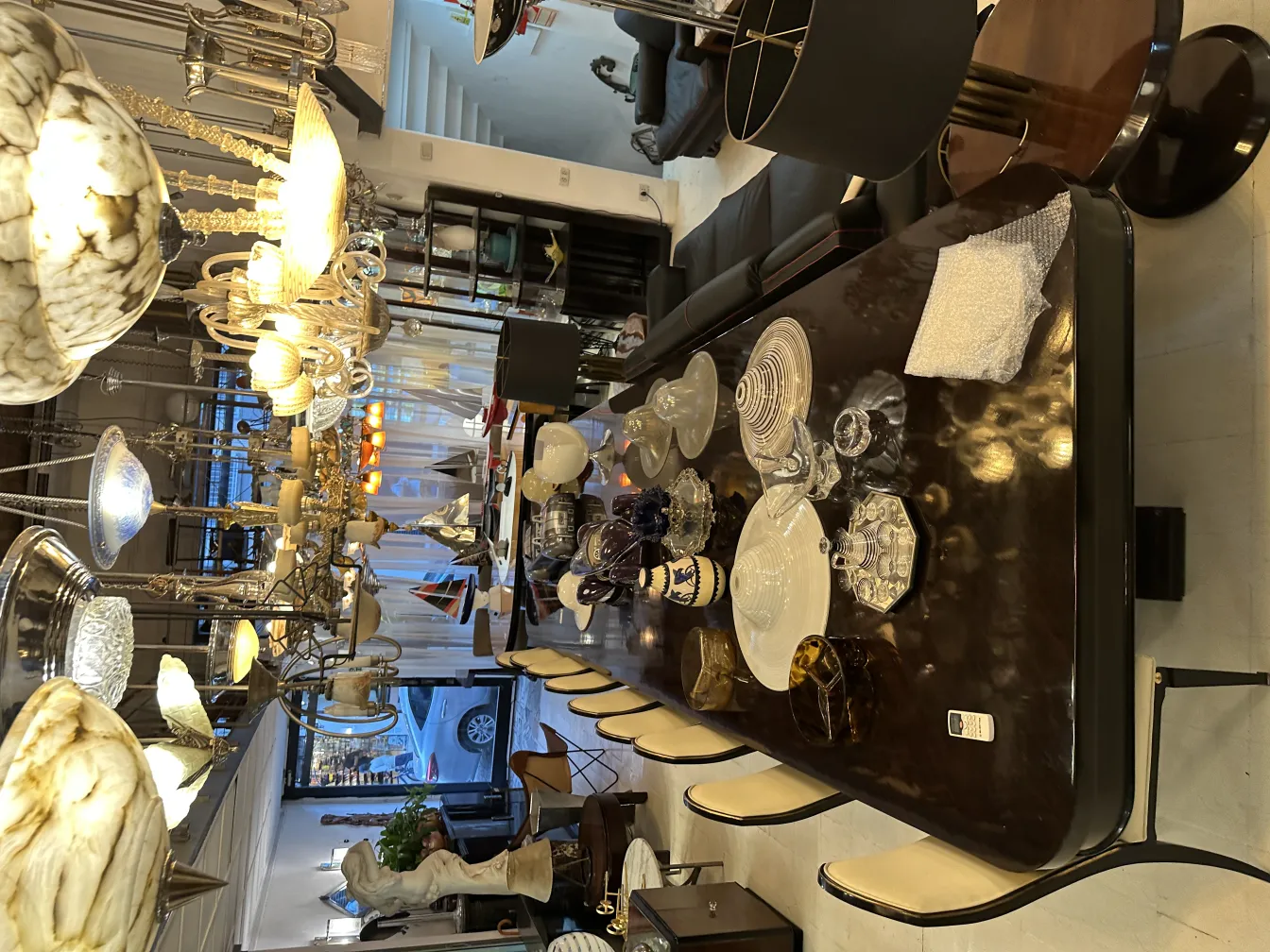 Lâmpada de teto antiga de vidro brilhante em um ambiente elegante com uma mesa decorada.