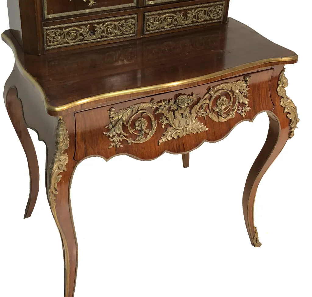 Antique desk with intricate carvings and golden decoration, cozy atmosphere.