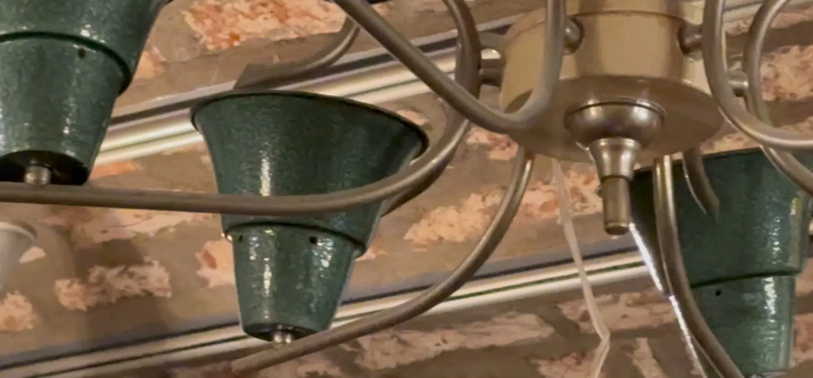 Antike Hängelampe mit künstlerischem Design in grün und beige.